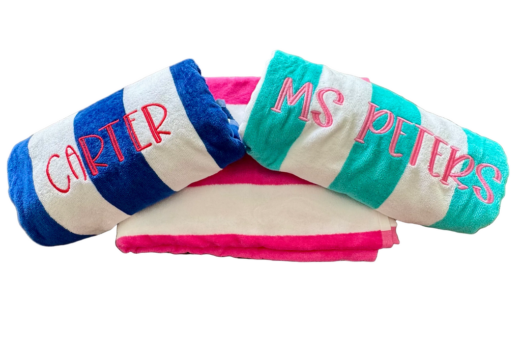 Rolled personalized beach towels in blue, turquoise, and pink – perfect teacher gifts